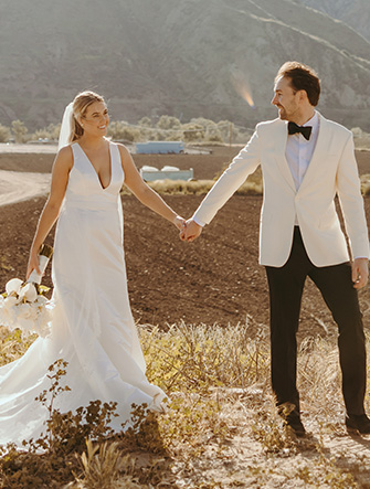 bride and groom holding hands walking