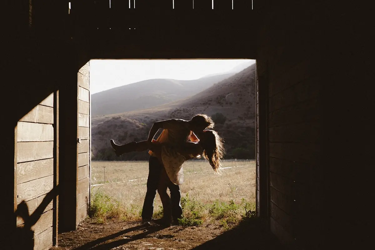 man kissing woman in barn